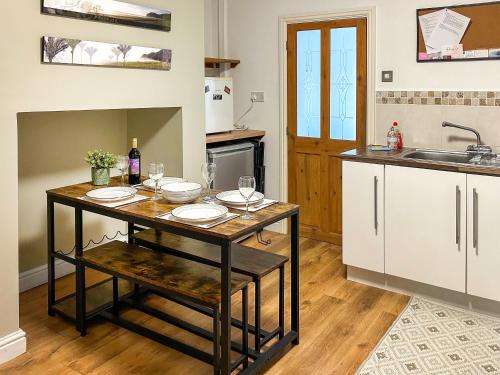 a kitchen with a table with wine glasses on it at Miner's Rest in Frizington