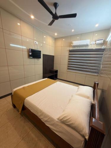 a bedroom with a bed with a ceiling fan at ars inn and mini hall in Tiruvallam