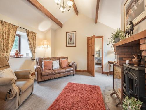 a living room with a couch and a fireplace at Beckside in Gilcrux