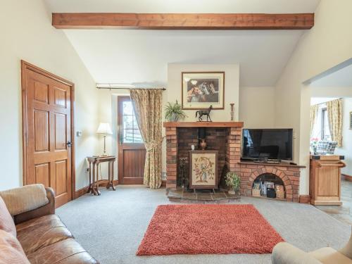 a living room with a couch and a fireplace at Beckside in Gilcrux