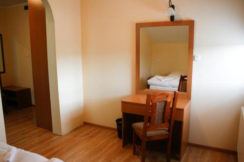 a room with a desk with a mirror and a bed at Hotel 7 in Szczecin