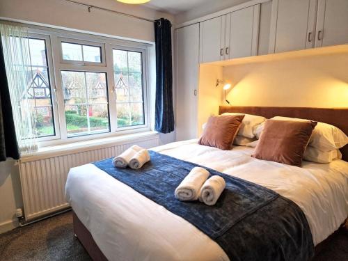 a bedroom with a large bed with rolled towels on it at Central modern home with parking in Nantwich