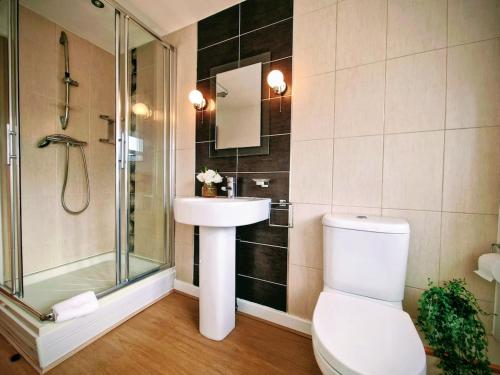 a bathroom with a shower and a toilet and a sink at Central modern home with parking in Nantwich