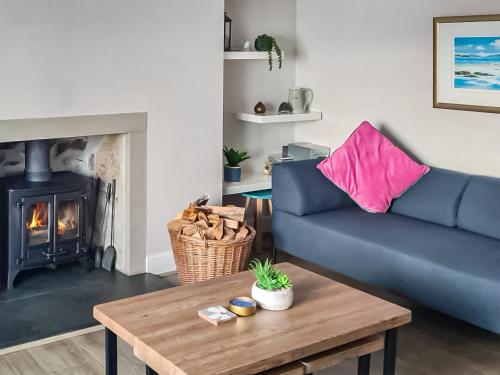 a living room with a blue couch and a fireplace at The Shore in Fortrose