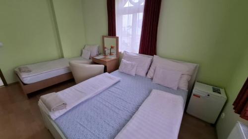 a small bedroom with two beds and a window at MAMRE Szálló in Hajdúböszörmény
