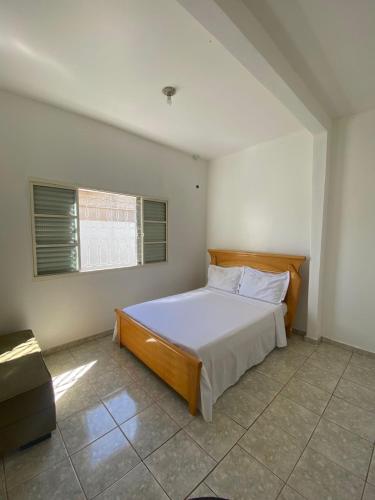 a bedroom with a bed and a window at Casa Jabuticabeira in Manhã