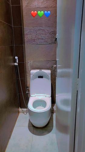 ein Badezimmer mit einer Toilette, an deren Wand drei Herzen angebracht sind. in der Unterkunft Emirimmo in Dakar