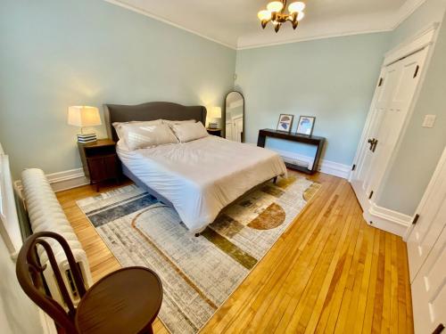 a bedroom with a bed and a table and a chair at The Sealy Residence in Saint John