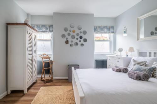 a white bedroom with a white bed and a desk at Danes House 4 in Aldeburgh