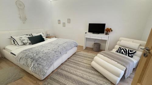 a bedroom with a bed and a desk with a television at Manland Vendégház Lillafüred in Lillafüred