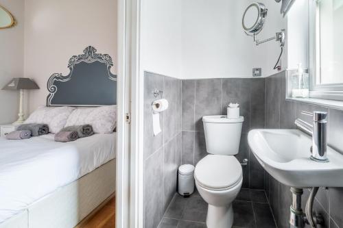 a bathroom with a toilet and a sink and a bed at Danes House 4 in Aldeburgh