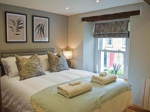 a bedroom with a bed with two towels on it at 14 Doomgate House - Uk45055 in Appleby