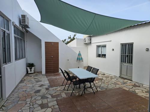 a patio with a table and chairs and a building at Blife Montya private rooms in Faro