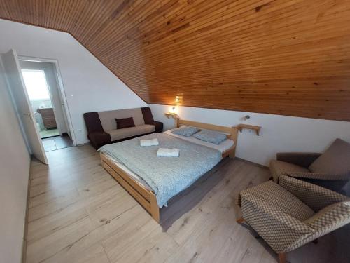 a bedroom with a bed and a couch and a chair at Parti nyaraló in Balatonfüred