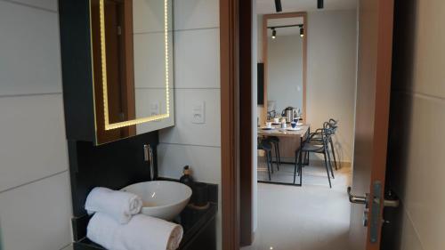 a bathroom with a sink and a room with a table at 098house in São Luís
