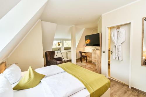 a bedroom with a large bed with a yellow blanket at Lounge-Hotel Seeterrassen in Wandlitz