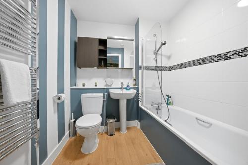 a bathroom with a toilet and a sink and a shower at Steps from Train Station - Modern 2-Bedroom with Balcony & Cambridge Amenities, Family Friendly in Cambridge
