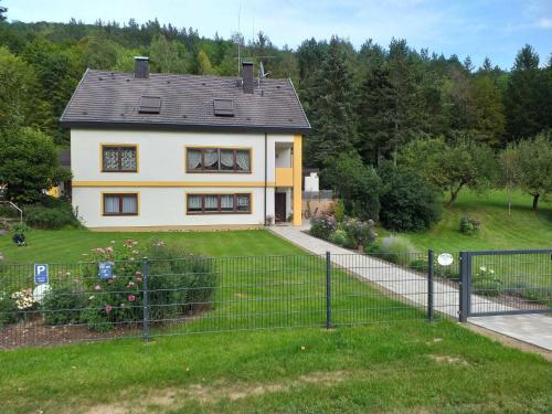 a house with a fence in front of a yard at Ferienwohnung Leicht in Heiligenstadt