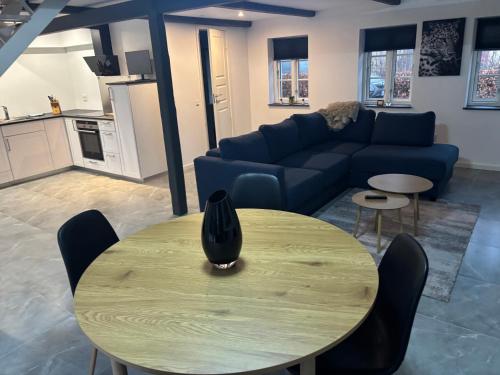 a living room with a table and a blue couch at House overlooking the countryside and close to the city in Middelfart