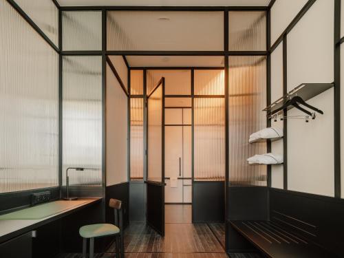 a bathroom with a bench and a glass wall at The Telegraph Hotel - The Leading Hotels of the World in Tbilisi City