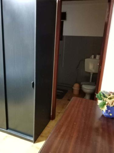 a bathroom with a toilet and a glass door at Moradia Lili in Ronqueira