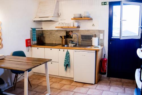 a small kitchen with a sink and a table at Mar - Boutique Garden Ocean View Suite in the Countryside - Vila Pilar in Ponta Delgada
