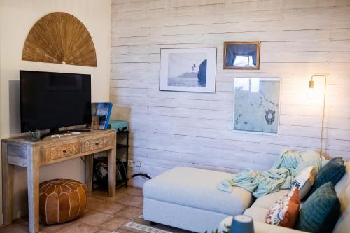 a living room with a couch and a television at Mar - Boutique Garden Ocean View Suite in the Countryside - Vila Pilar in Ponta Delgada