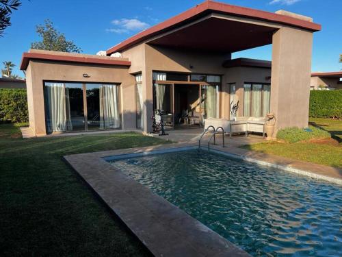 a house with a swimming pool in front of a house at Palms Edge Villas avec Piscine & Jardin Privés in Marrakesh