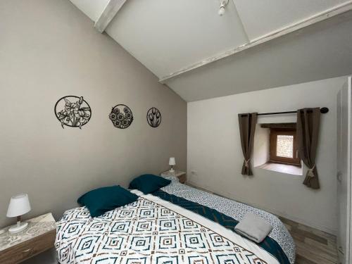 a bedroom with a bed with blue pillows and a window at Gîte des Nicolaux in Beauvène