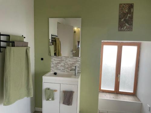 a bathroom with a sink and a mirror at Gîte des Nicolaux in Beauvène