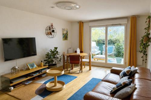a living room with a couch and a table at Passion et détente by UTA HOUSE in Saint-Denis