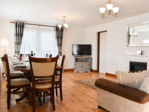 a living room with a dining room table and a television at Wesley Old Hall House in Bacup