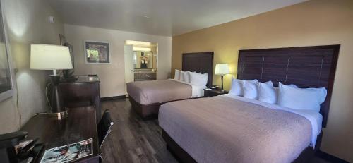 a hotel room with two beds and a mirror at SureStay by Best Western Mesa Downtown Area in Mesa