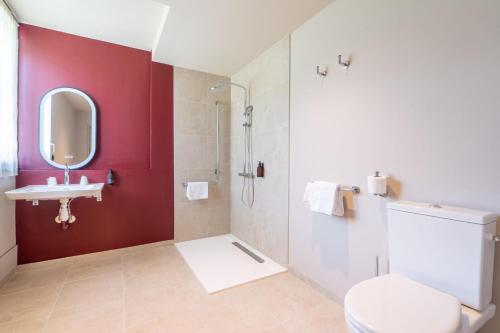 a bathroom with a white toilet and a sink at Best Western Hôtel du Phare in Mérignac