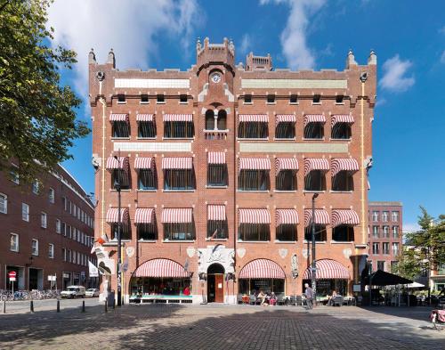 a large brick building on a city street at Berlage Hotel, BW Signature Collection in The Hague