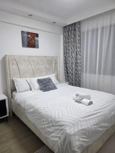 a bedroom with a large white bed with a large window at Purplehaze Place in Nairobi