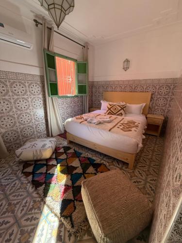 a bedroom with a bed and a rug at Riad R Art in Marrakesh