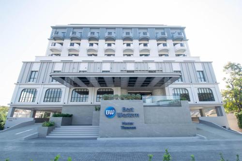 a white building with a sign in front of it at Best Western Matter Tiwanon Hotel in Bangkok