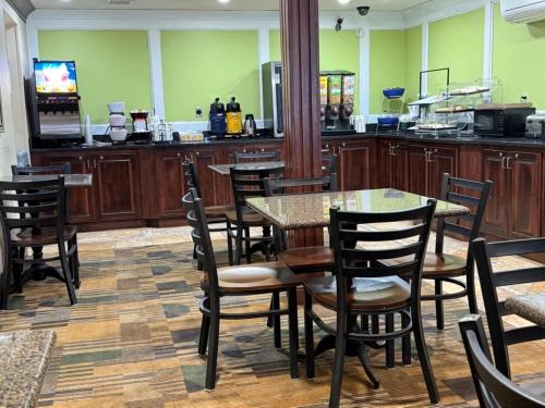 a dining room with tables and chairs and a television at SureStay by Best Western Grove City in Grove City