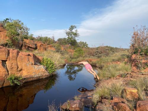 a person is jumping into a pool of water at Bateleur Nature Reserve & Stamvrug Hiking Trails in Modimolle