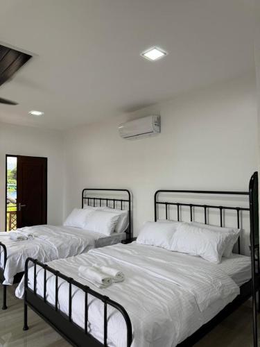 two beds sitting next to each other in a bedroom at GG Studio in Kampong Sura