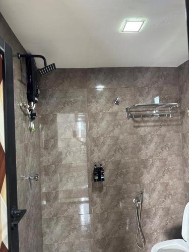 a bathroom with a shower with a tiled shower at GG Studio in Kampong Sura