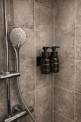 a shower with two bottles of soap in a bathroom at Studio-Apartament 101 free Parking Domus Kushal in Viersen