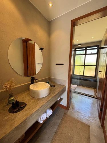 a bathroom with a sink and a mirror at Confraria da Prata Flats in Pirenópolis