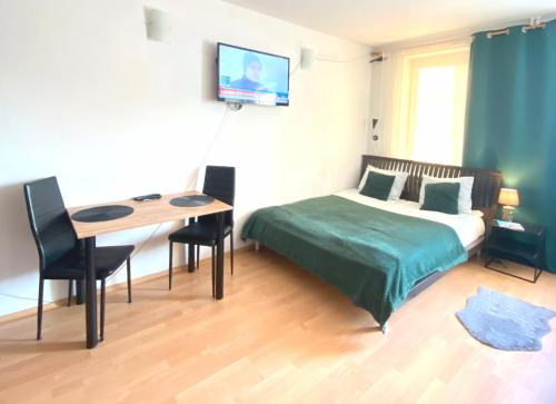 a bedroom with a bed and a desk and a television at Apartamenty przy Starówce in Olsztyn