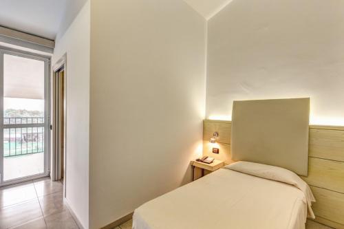 a small bedroom with a bed and a window at HOTEL HMR RHO Milano in Rho
