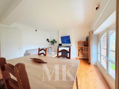 a dining room and living room with a table at L'Authentic - Appartement spacieux in Villeneuve-sur-Yonne