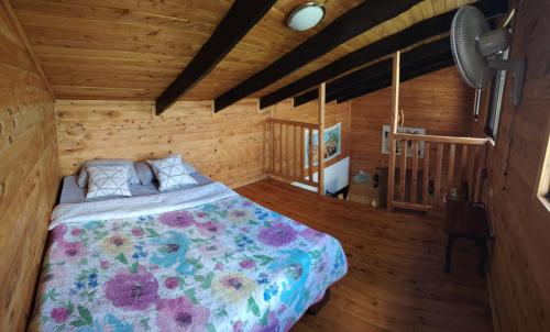 a bedroom with a bed in a wooden room at Cabaña la Corteza in Tanque
