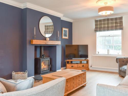 a living room with a fireplace and a tv at Fern House in Hinderwell