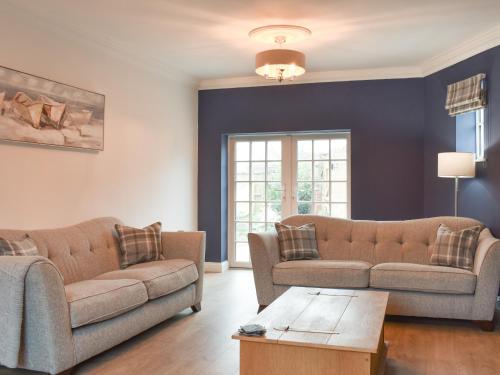 a living room with two couches and a table at Fern House in Hinderwell